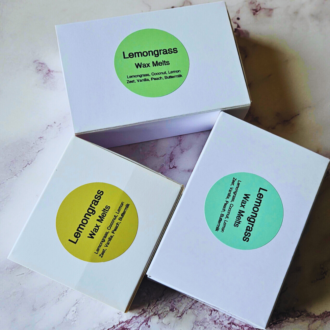 Three boxes of Lemongrass wax melts on a marble surface