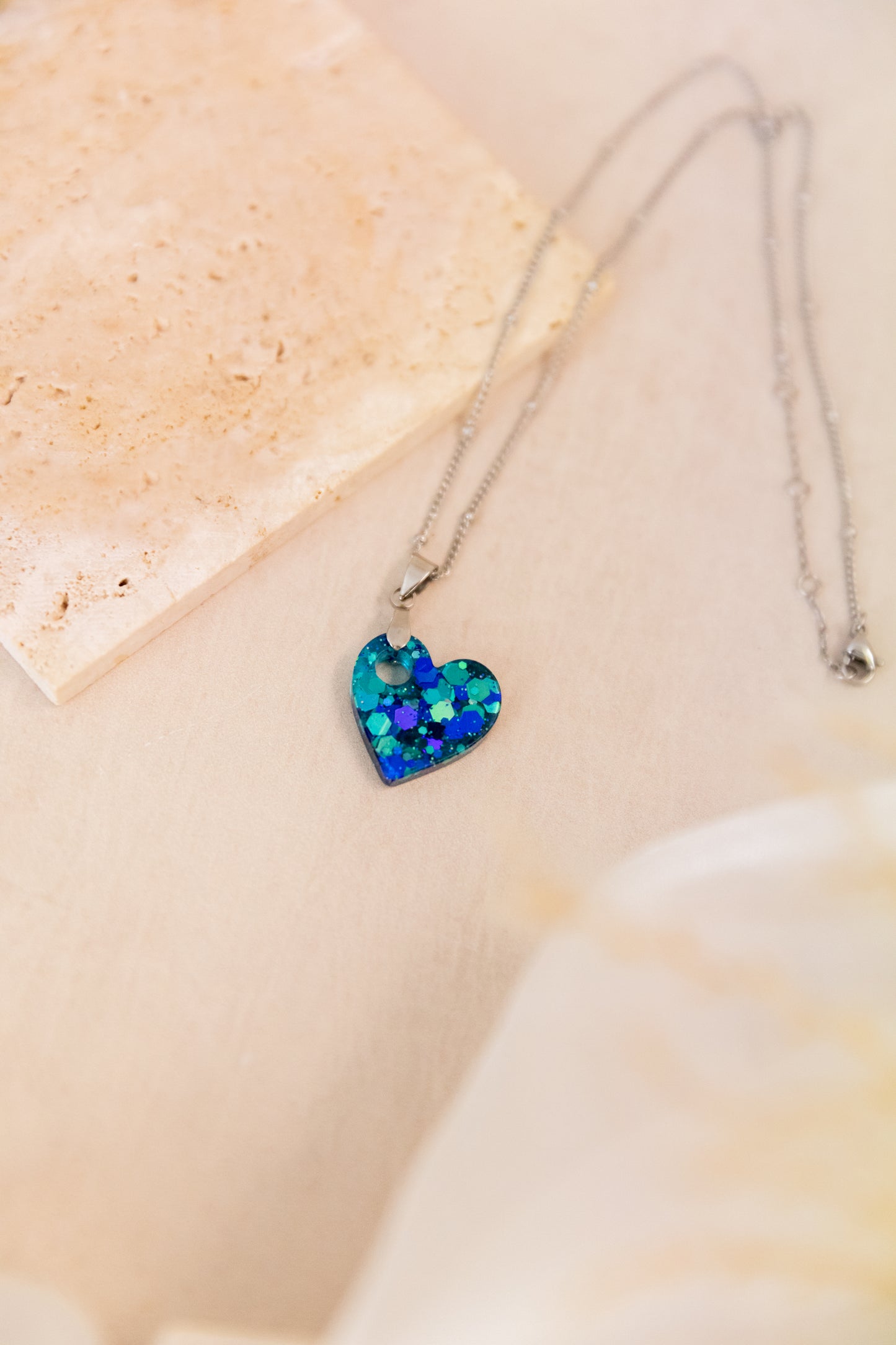 Necklace with a blue heart-shaped pendant on a light background