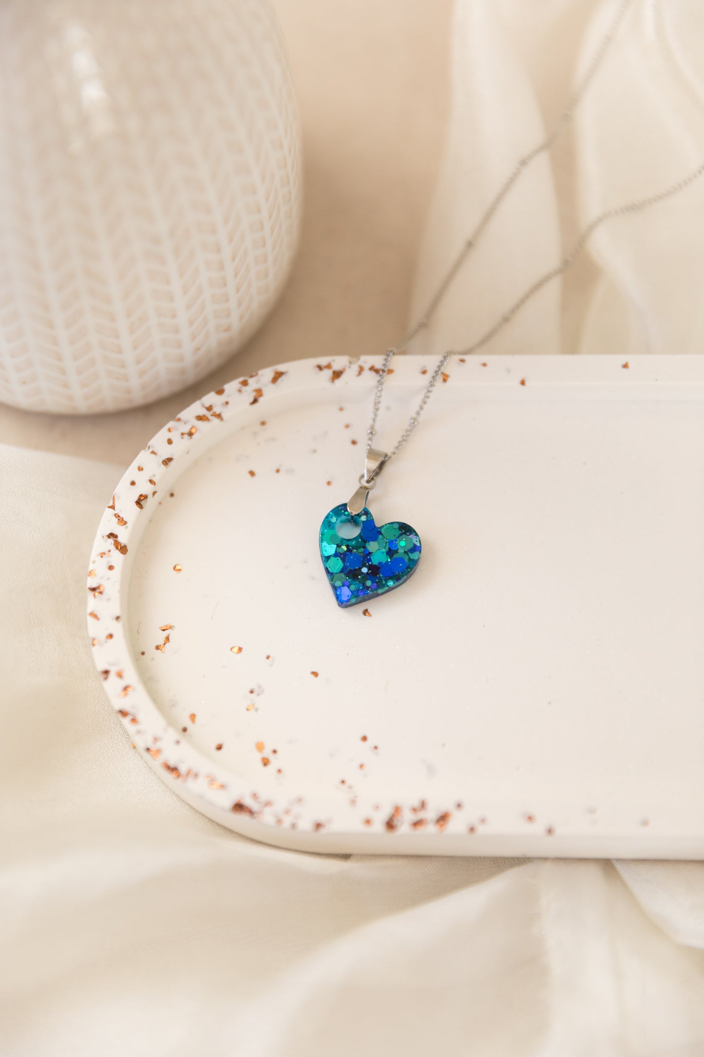 Necklace with a heart-shaped blue pendant on a white surface