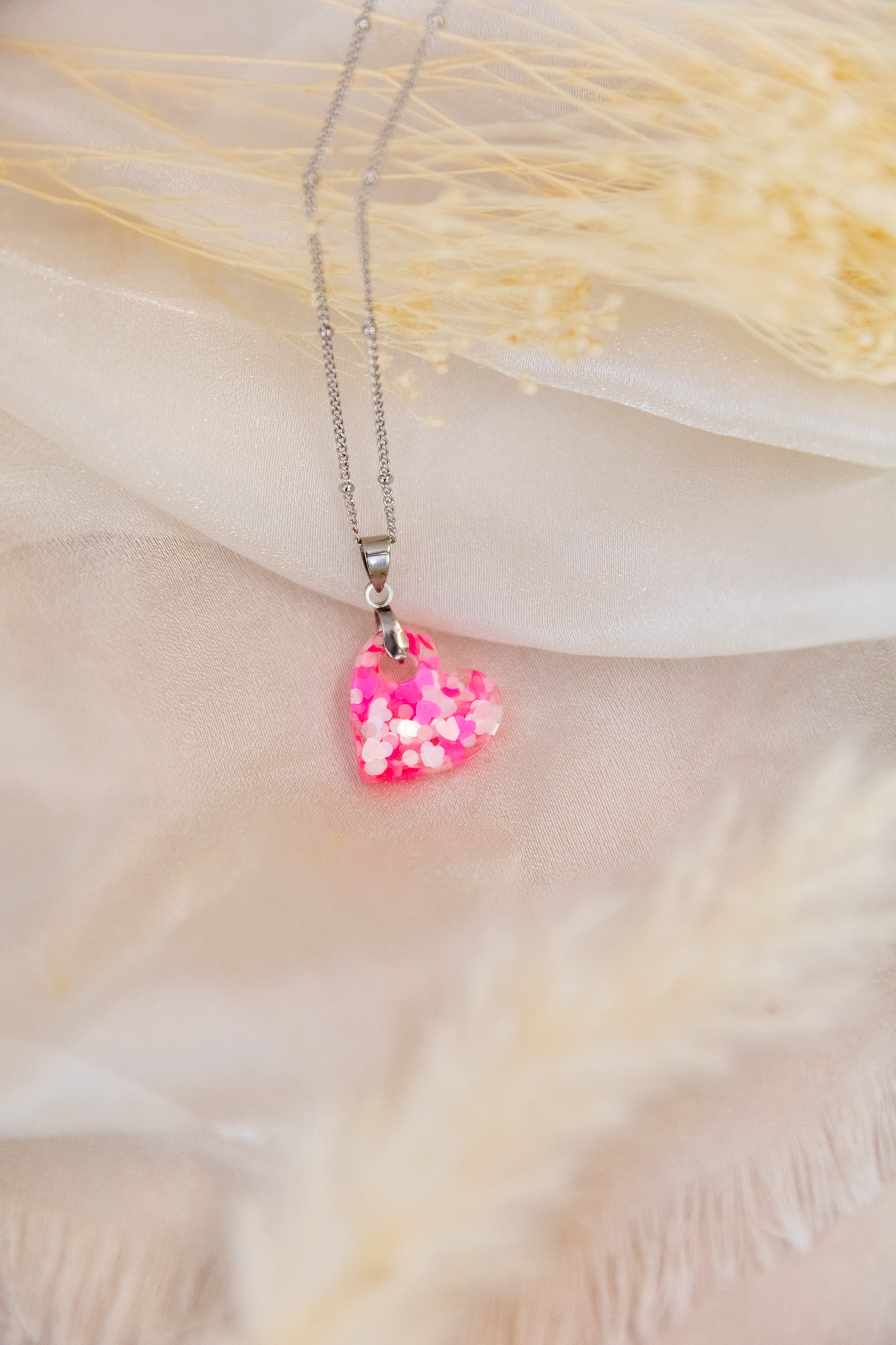 Necklace with a pink heart-shaped pendant on a soft background