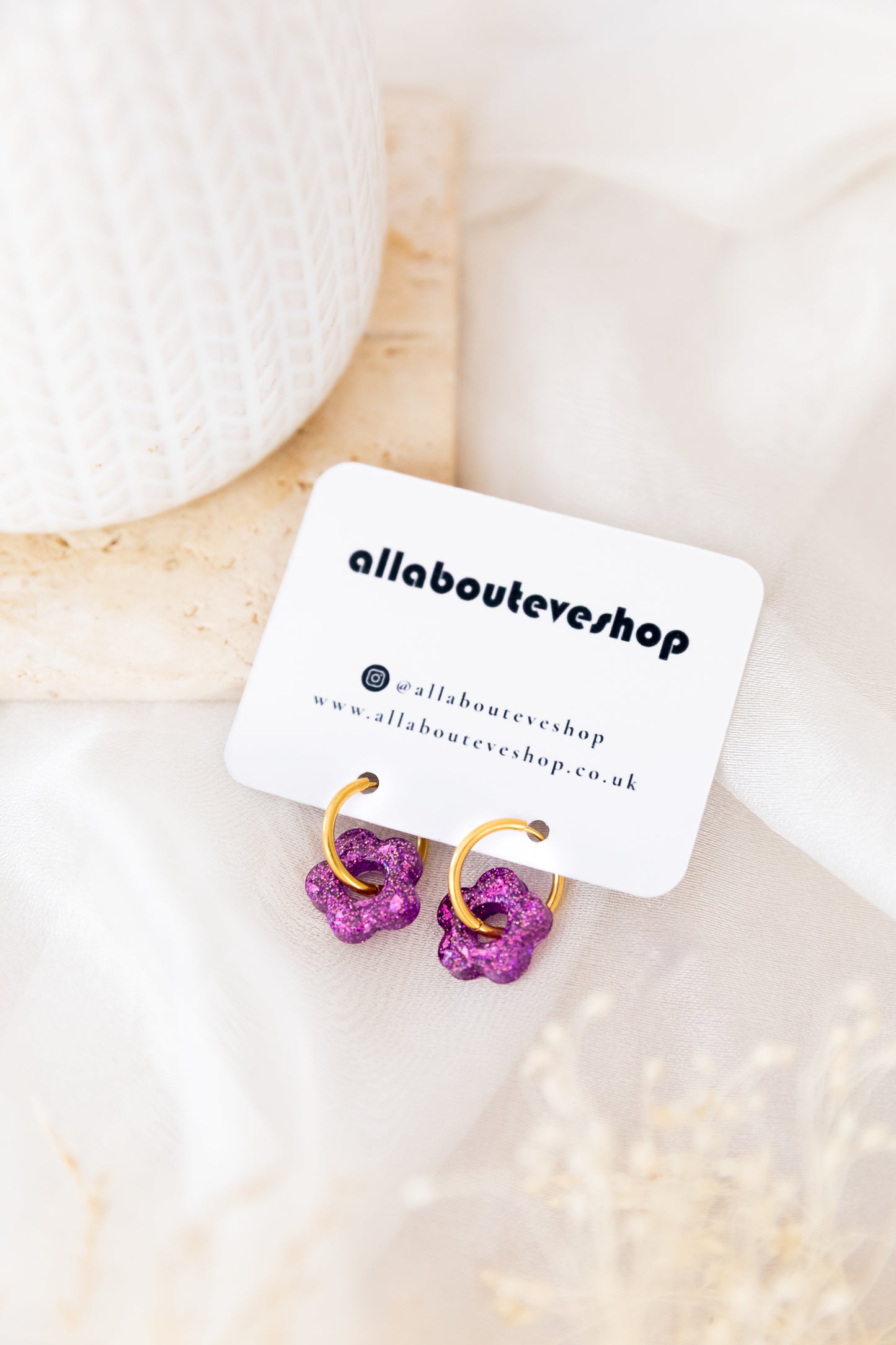 Purple earrings on a white card with 'allaboutevevshop' branding, placed on a soft white background.