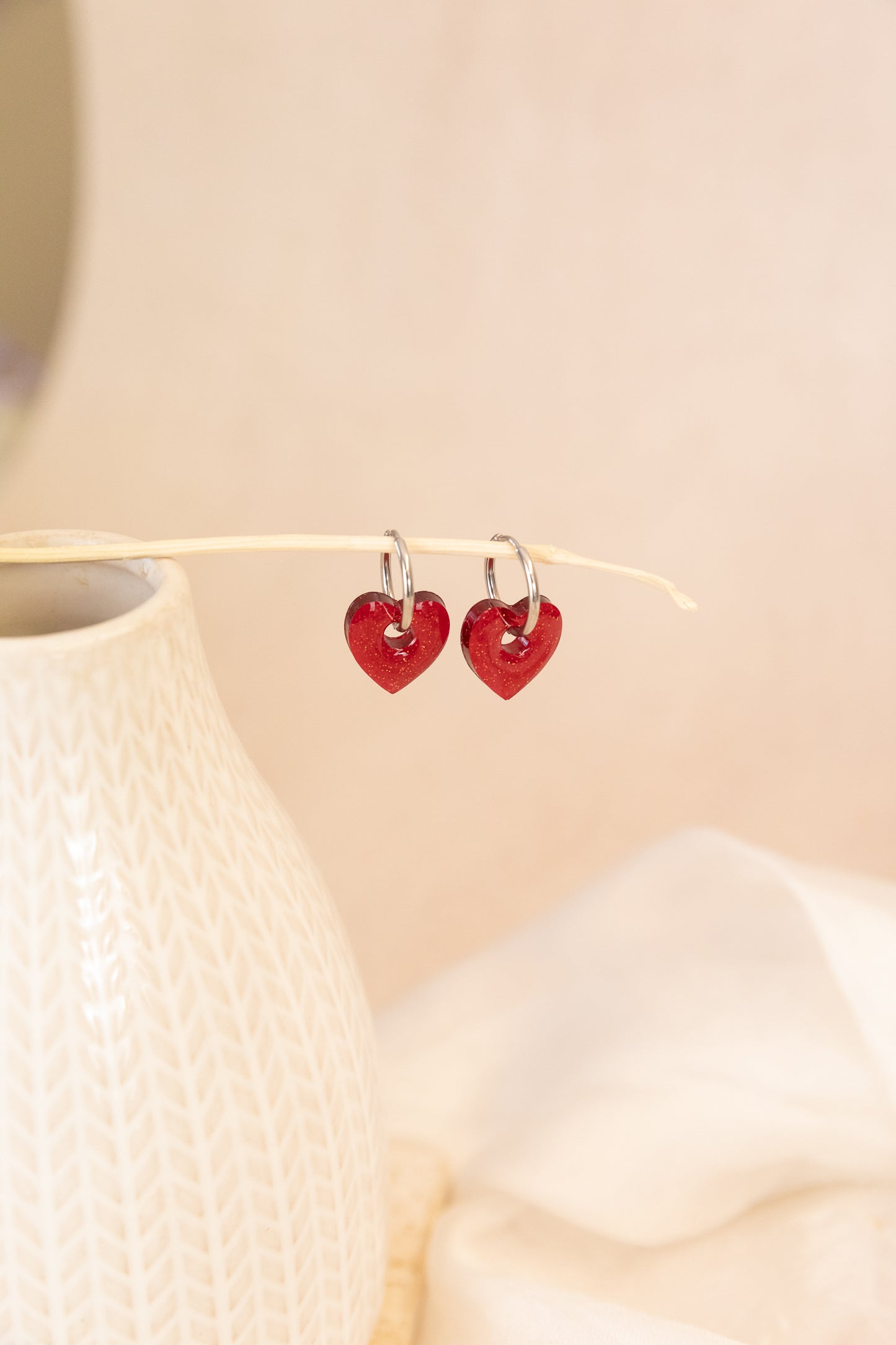 Heart-shaped earrings on a beige background